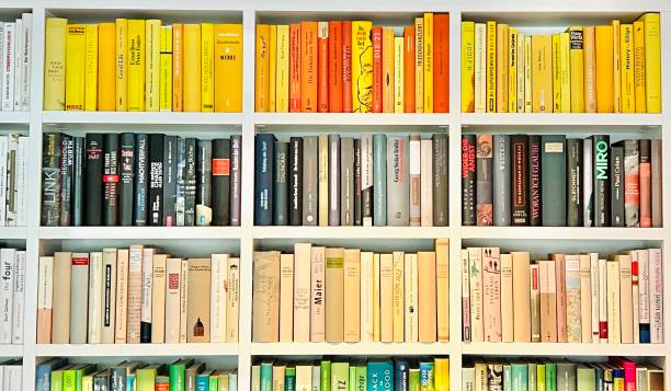 istock Bookshelves fully packed, white wood, different colors book spines series 1397331068