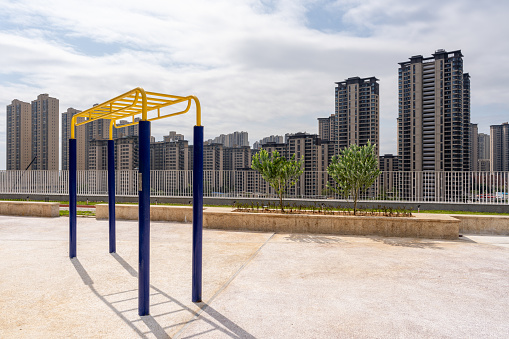 A fitness equipment in the open space and a city building in the distance