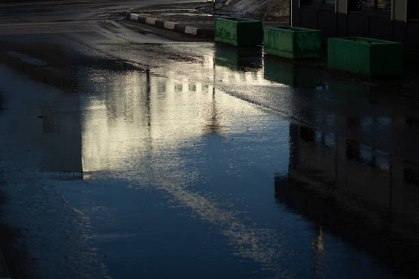 istock Puddle in road. Wet asphalt. Spring weather. 1397332053