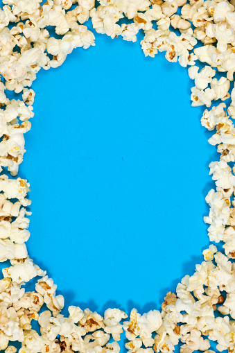 Popcorn on a blue background, corn kernels top view