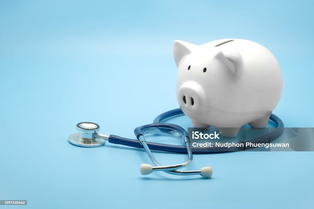 Piggy bank with stethoscope isolated on light blue background with copy space. Health care financial checkup or saving for medical insurance costs concept. Healthcare And Medicine Stock Photo