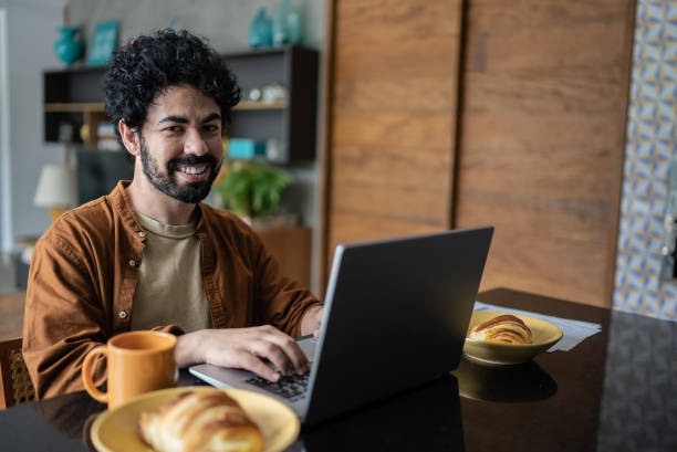 istock Portrait of man using laptop at home 1397340803