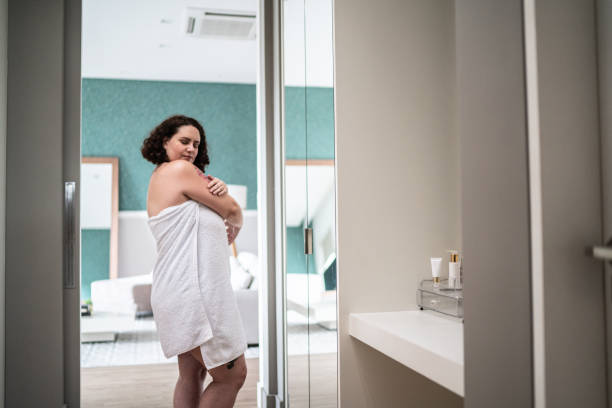 istock Woman wearing a towel applying moisturizer at home 1397340974