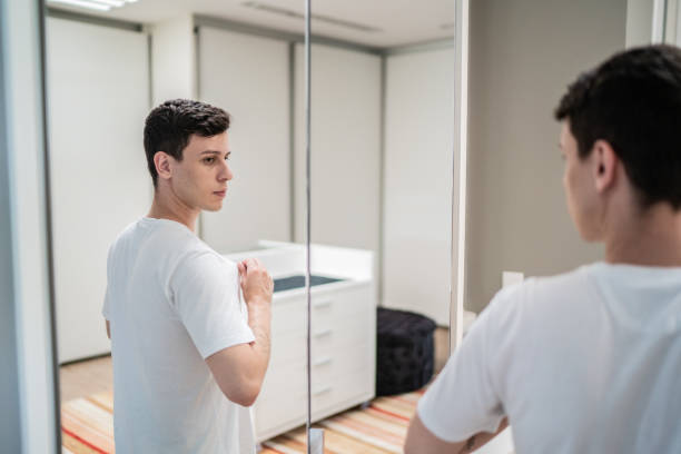 istock Young man looking in the mirror at home 1397341111