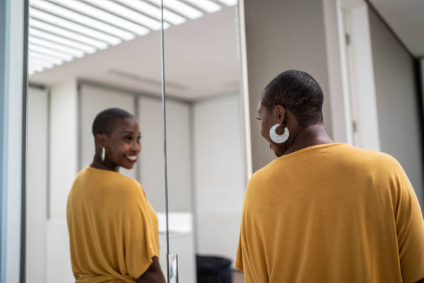 femme adulte se regardant dans le miroir à la maison - mirror women dress looking photos et images de collection