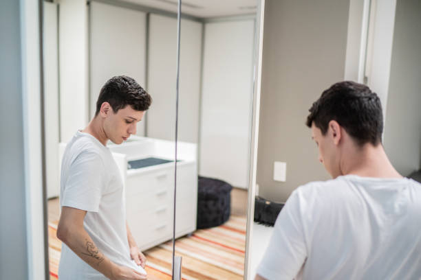 istock Young man getting dressed and looking in the mirror at home 1397341144