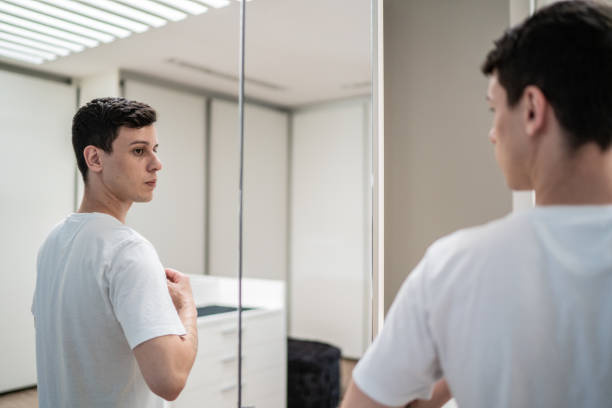 istock Young man getting dressed and looking in the mirror at home 1397341151