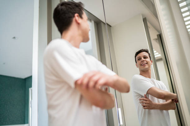 istock Young man getting dressed and looking in the mirror at home 1397341153