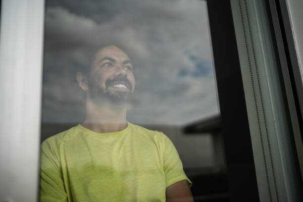 istock Contemplative mid adult man looking through window 1397341299