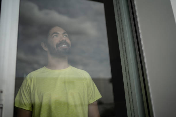 istock Contemplative mid adult man looking through window 1397341306