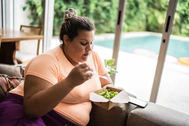 Mid adult woman eating salad at home