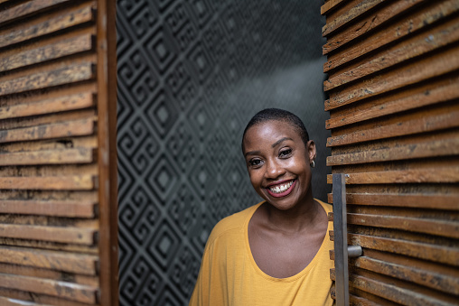 Portrait of a mid adult woman opening the door at home