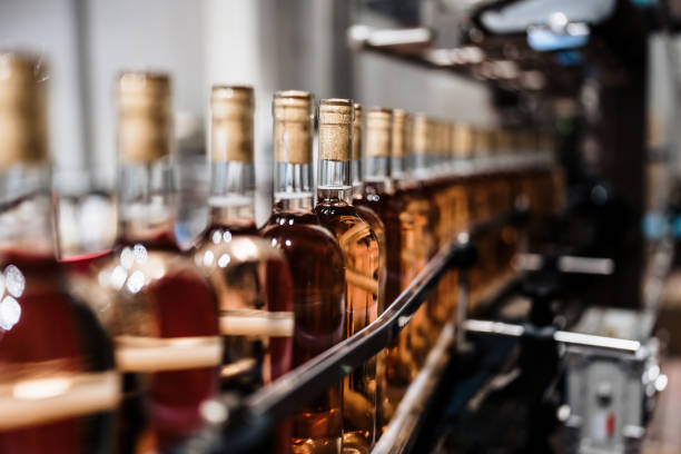 Industrial wine bottling production line Industrial wine bottling plant theme. Modern industry production line for alcohol drink bottling and packaging. bottling plant stock pictures, royalty-free photos & images