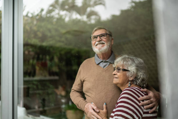 istock Contemplative senior couple looking though window at home 1397342788