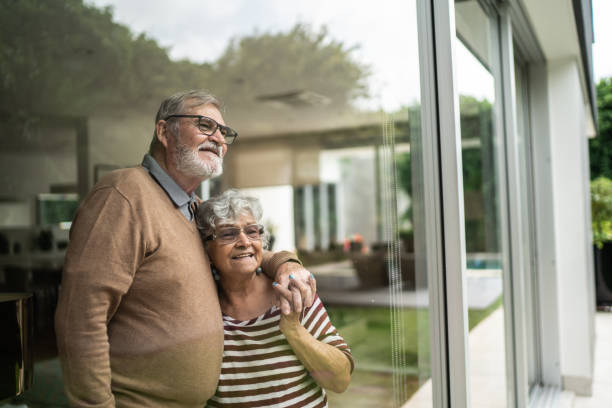 istock Contemplative senior couple looking though window at home 1397342820
