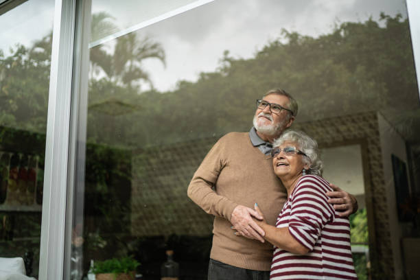 istock Contemplative senior couple looking though window at home 1397342834