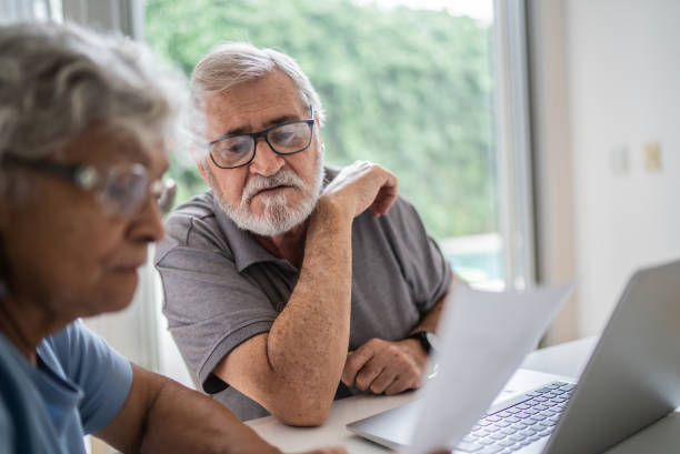 istock Senior couple talking about home finances and using the laptop at home 1397343623