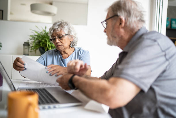 istock Senior couple talking about home finances and using the laptop at home 1397343726