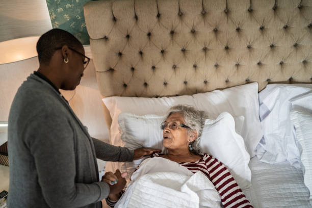 istock Nurse helping a senior woman lying down in the bed 1397344026