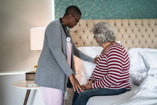 istock Nurse helping a senior woman lying down in the bed 1397344066