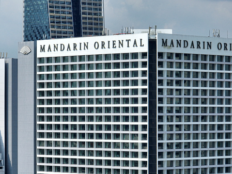 The facade of the Mandarin Oriental hotel in Singapore Marina Bay area seen at day in the summer.