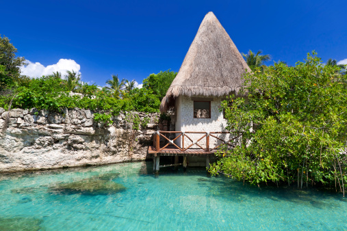 Idyllic mexican jungle scenery with hut on the water