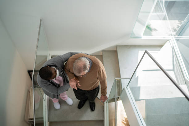 istock Home caregiver helping patient walking on the stairs 1397344949
