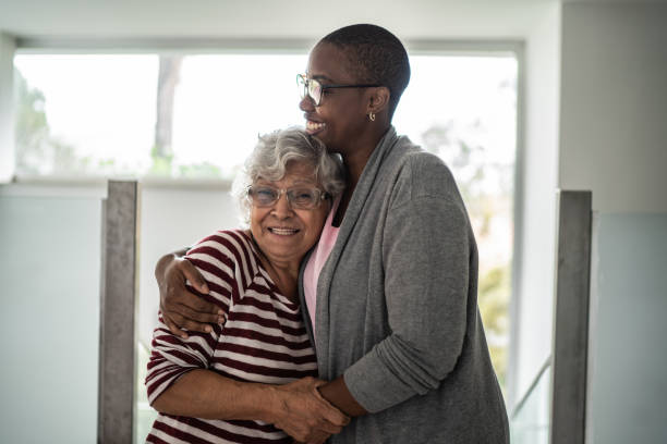 Nurse and senior woman embracing at home Nurse and senior woman embracing at home community outreach stock pictures, royalty-free photos & images