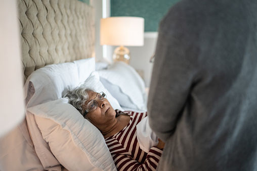 Caregiver talking to a senior woman in the bedroom