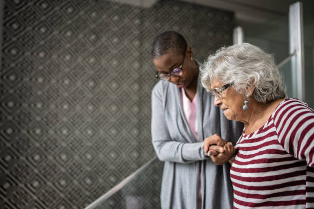 une infirmière aide une femme âgée qui monte les escaliers - healthcare worker home caregiver senior adult care photos et images de collection