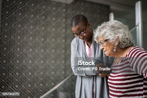 istock Nurse helping a senior woman walking the stairs 1397345175