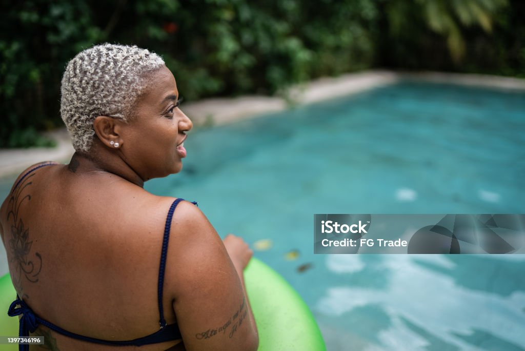 Woman enjoying swimming pool at house Obesity Stock Photo
