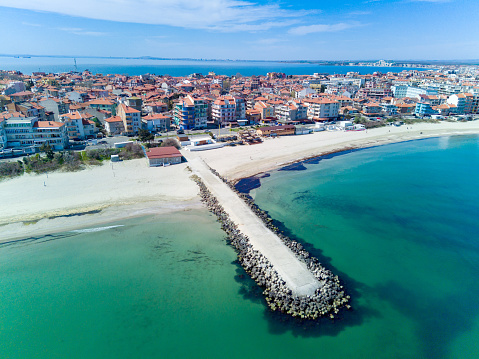 Panoramic bird's eye view over small ancient resort town of Pomorie with old European small houses and quiet calm empty streets, washed by the sea spring turquoise Black Sea on clear day in Bulgaria