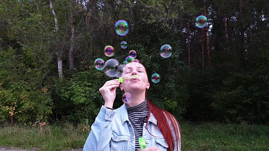 young woman blowing bubbles in the Park on a summer evening.