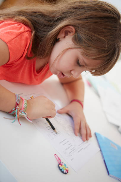 petite fille faire ses devoirs - enfant prodige photos et images de collection