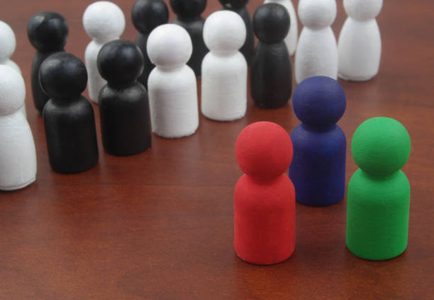 three colored wooden figures as leaders standing near crowd of white and black figures. - surrounding leadership organization meeting imagens e fotografias de stock