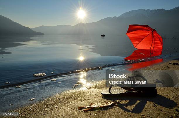 Infradito E Un Ombrellone Sulla Spiaggia Rosso - Fotografie stock e altre immagini di Lago - Lago, Sabbia, Svizzera