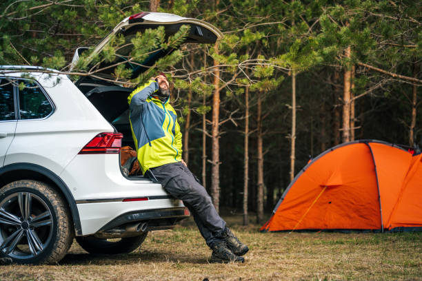istock A man talking on the mobile phone while sitting in the open trunk of an SUV. 1397356800