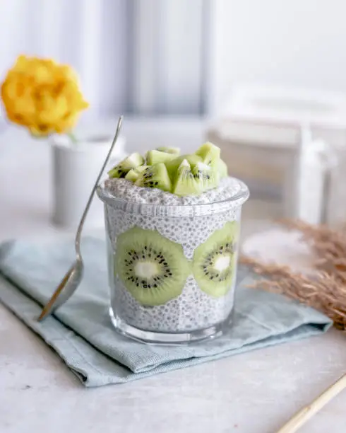 A jar of chia pudding decorated and topped with kiwi fruit