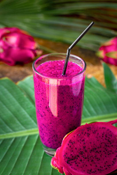 Fresh smoothies from a dragon fruit  in glass.  juice and fresh pitahaya on a tropical background stock photo
