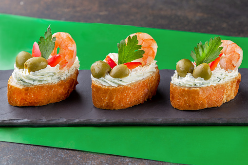 Bruschetta with cream cheese, olives and shrimps