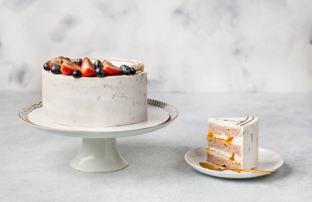 gâteau blanc festif décoré de baies sur fond clair. concept de bonbons pour la fête des mères, le jour du mariage, la saint-valentin - plat à gâteau photos et images de collection