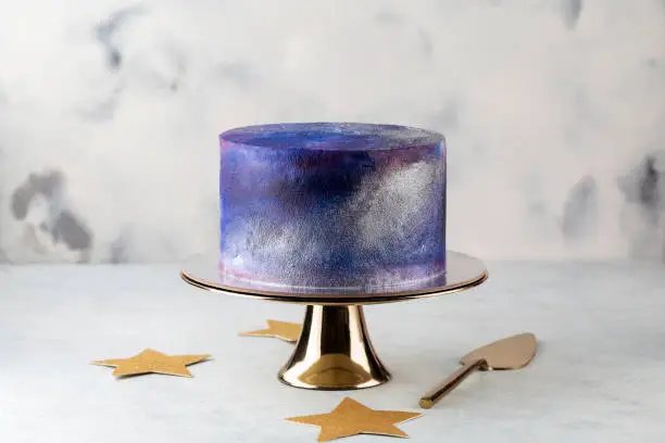 festive big blue cosmic cake on a light background. Sweets concept .