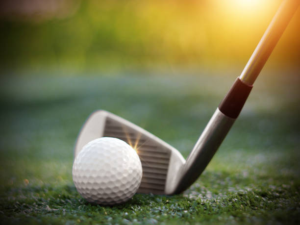 golfball nahaufnahme auf abschlagsgras auf verschwommener wunderschöner landschaft mit golfhintergrund. konzeptieren sie internationalen sport, der auf präzisionsfähigkeiten zur gesundheitlichen entspannung setzt." t - golf power golf course challenge stock-fotos und bilder