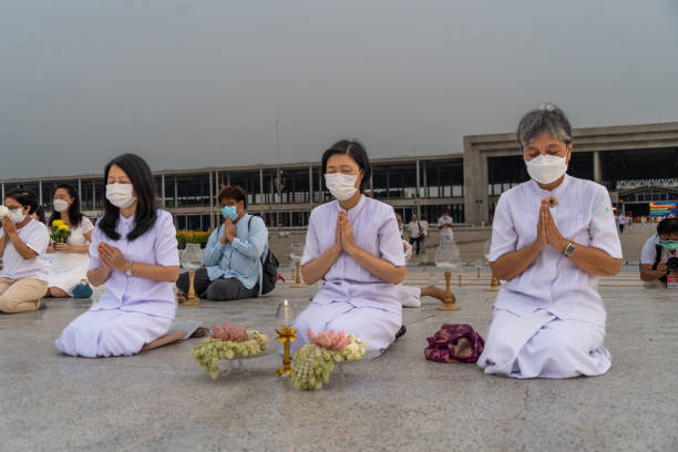Devotees pray together at a ritual. Wat Phra Dhammakaya commemorates International Vesak Day (Visakha Bucha) by lighting 210,000 LEDs depicting the Lord Buddha's Birth, Enlightenment, and Great Decease.