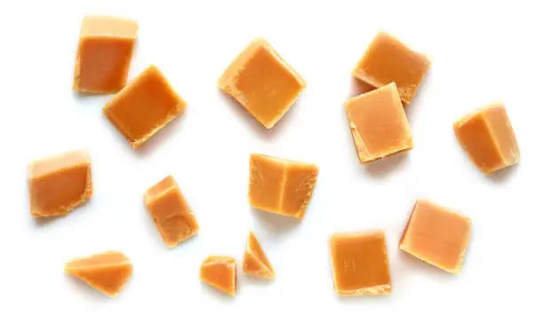 Photo of caramel pieces on white background