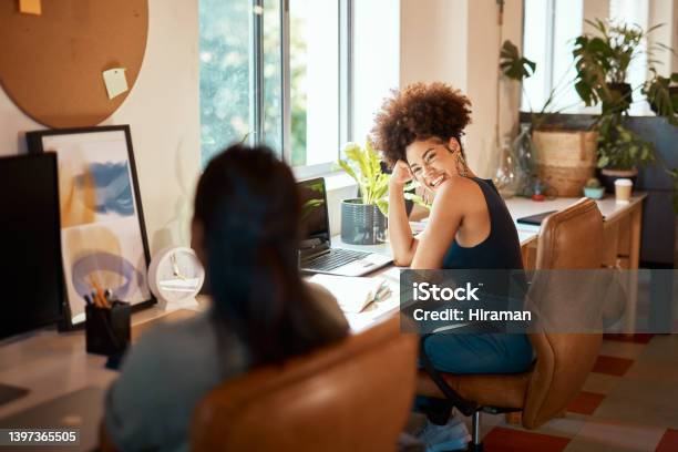 Beautiful Mixed Race Creative Business Woman Laughing With A Female Colleague Two Young Female African American Designers Working In Their Office Happy Entrepreneurs Make The Most Productive Workers Stock Photo - Download Image Now