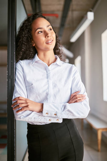istock Confident young mixed race business woman thinking of ideas while standing alone with her arms folded in her office. Contemplative and ambitious hispanic entrepreneur posing with her arms crossed 1397366374