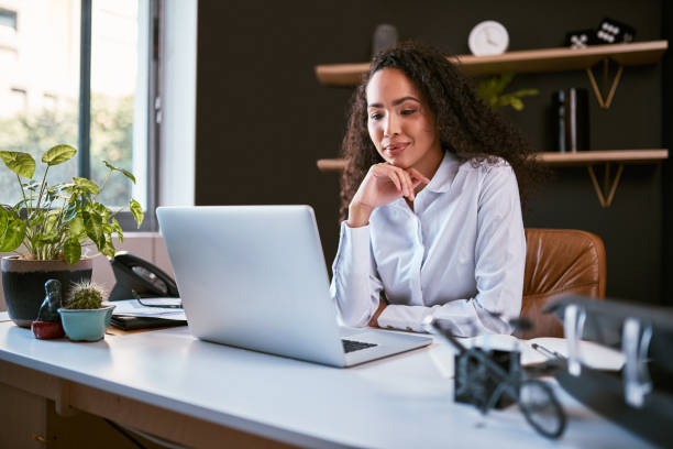 istock Young and ambitious mixed race entrepreneur sitting alone and thinking while browsing the internet on a laptop in an office. Hispanic business woman using a computer to plan her freelancing startup 1397367471