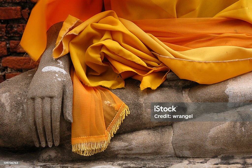 Buddha Hand Wrapped in Orange Fabric Stone hand of Buddha statue wrapped in orange curtain in Nakhon Pathom, Thailand. Buddha Stock Photo